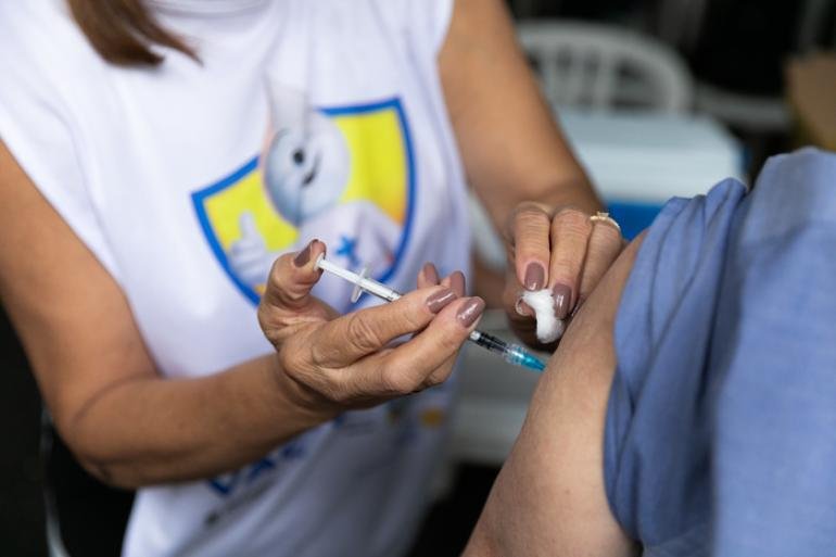 Profissional de saúde aplica vacina no braço de uma pessoa