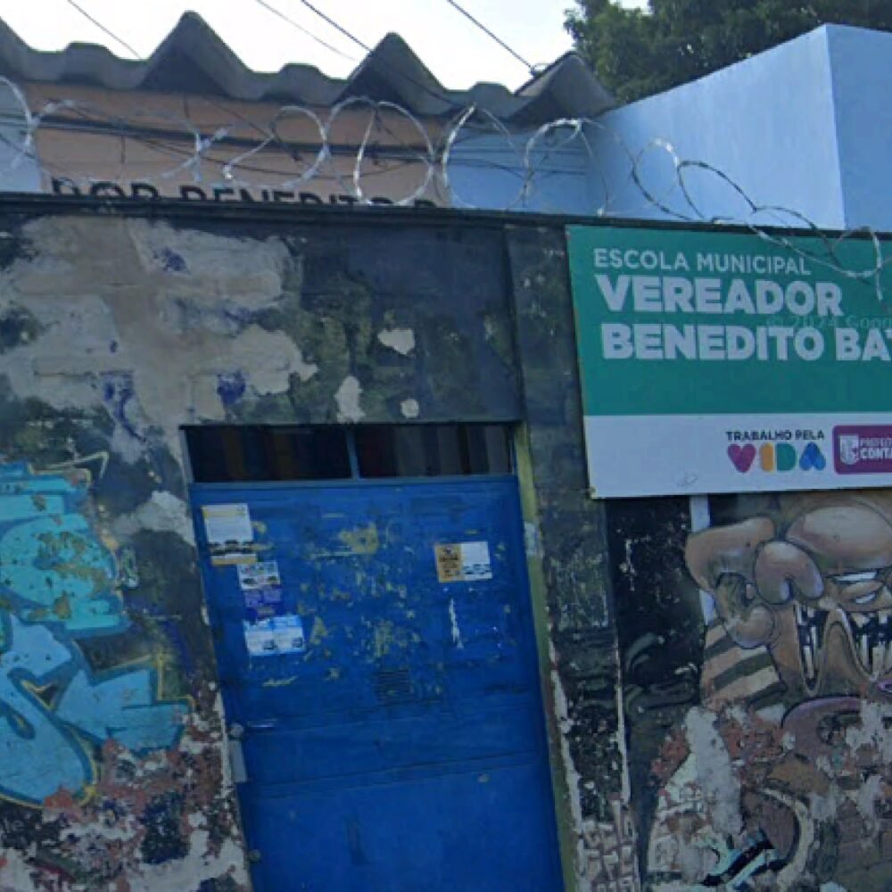 Fachada da Escola Municipal Vereador Benedito Batista com portão azul e placa verde na Grande BH