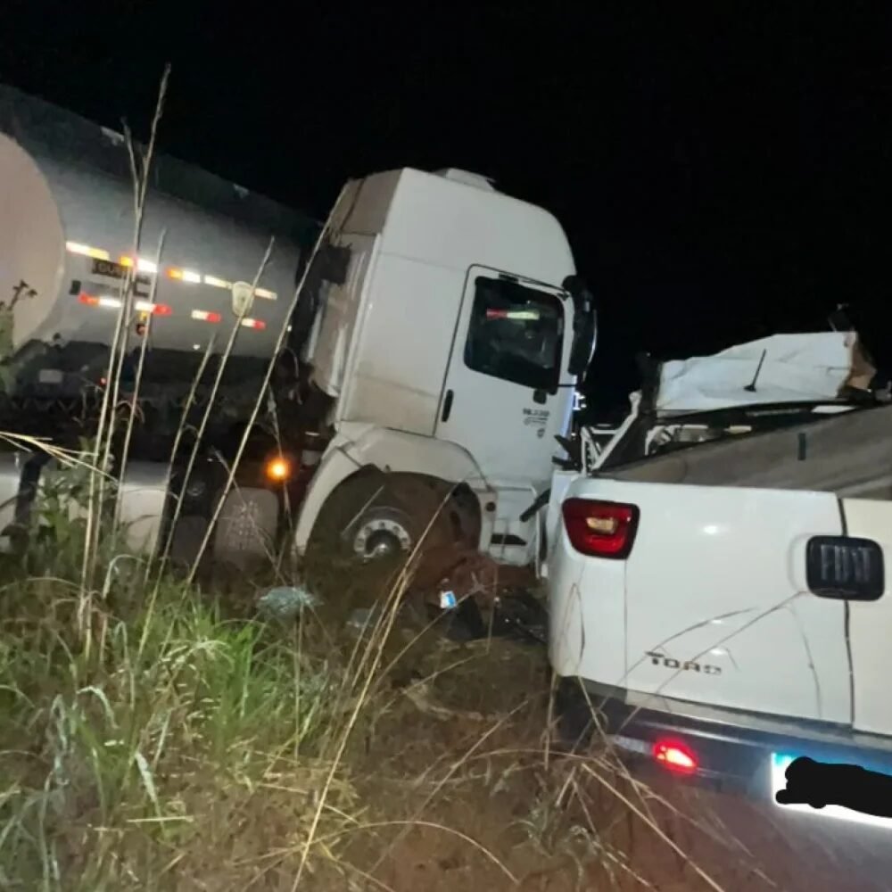 Carreta branca com tanque e caminhonete destruídas após batida à noite na rodovia
