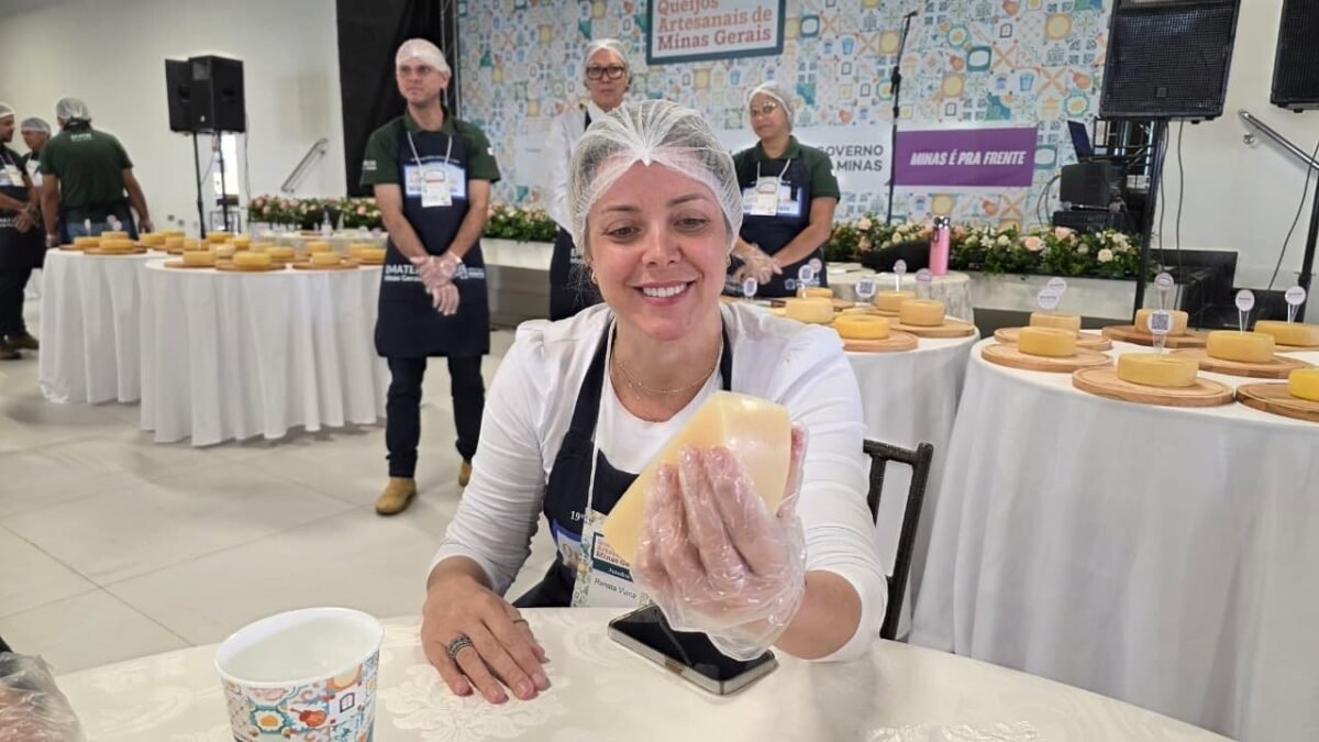 Mulher sorri enquanto avalia um pedaço de queijo durante concurso em Diamantina
