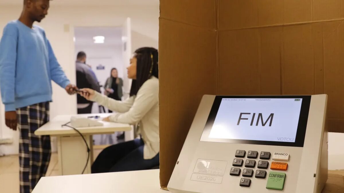 Eleitores aguardam na fila para votar em seção eleitoral.